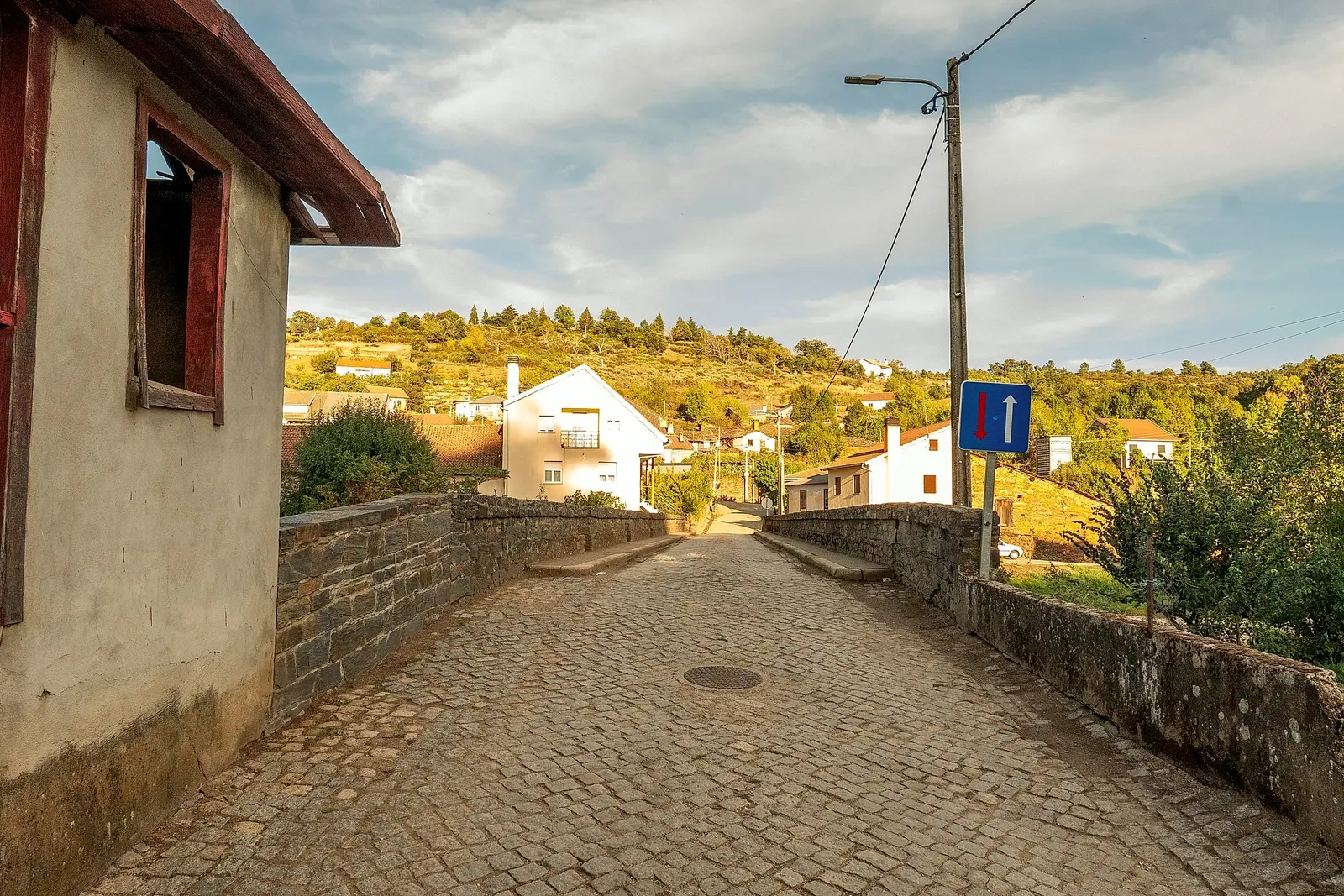 Ponte calcetada à entrada da aldeia, com as casas ao fundo