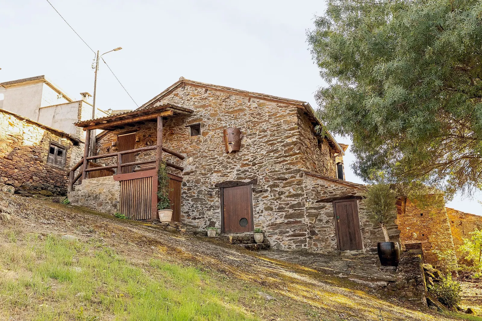 Casa de xisto com varanda de madeira, na encosta
