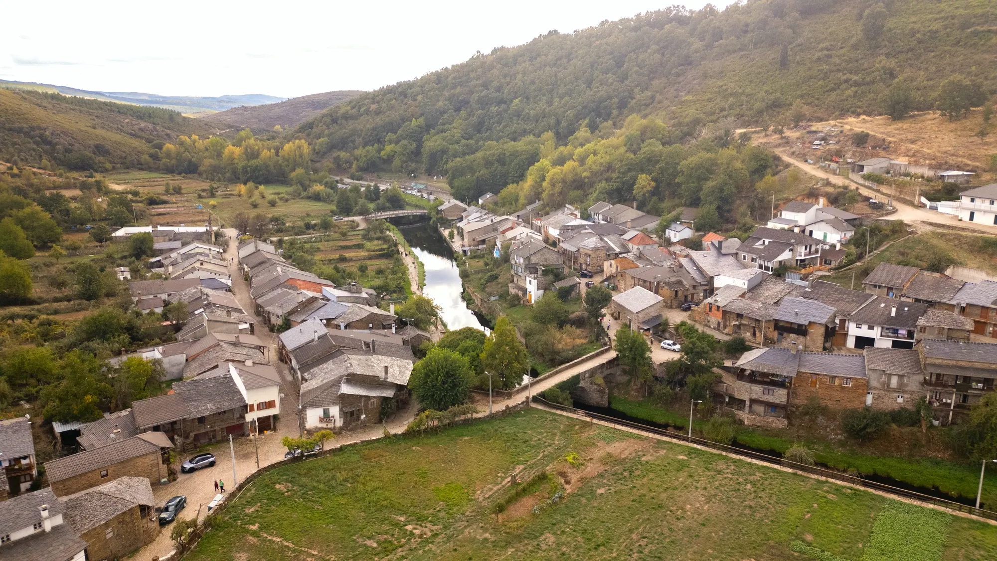 Vista aérea de Rio de Onor, com as casas de xisto junto ao rio e aos campos