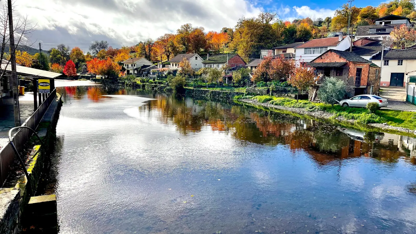 O rio de Varge no outono, com as casas da aldeia refletidas na água